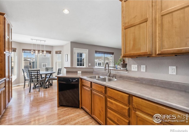 kitchen with sink, decorative light fixtures, dishwasher, and light wood-type flooring