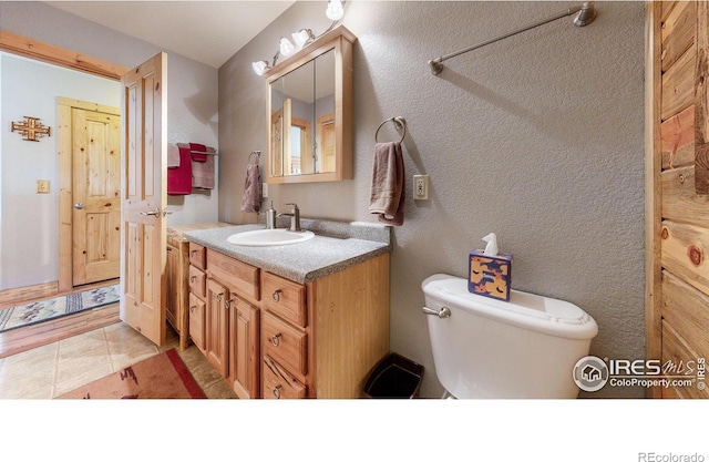 bathroom featuring vanity, tile patterned floors, and toilet