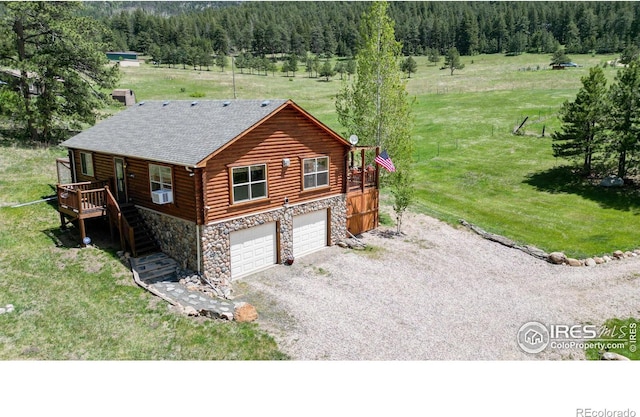 view of front facade with a garage, cooling unit, a deck, and a front lawn