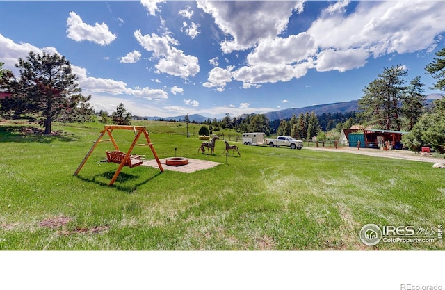 exterior space featuring a mountain view and a fire pit