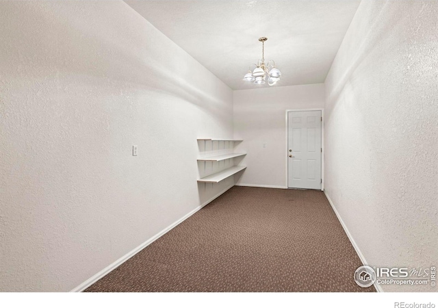 spacious closet featuring a chandelier and carpet