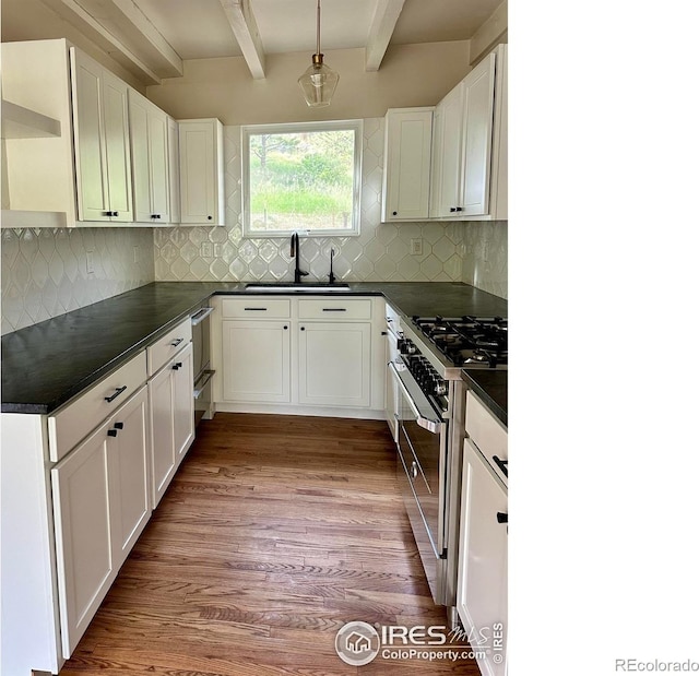 kitchen with decorative light fixtures, sink, white cabinets, high end range, and beam ceiling