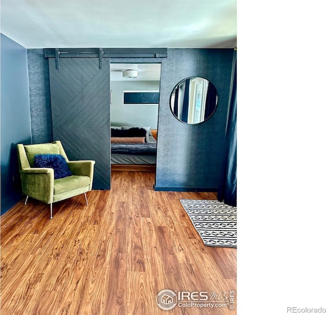 living area featuring hardwood / wood-style flooring and a barn door