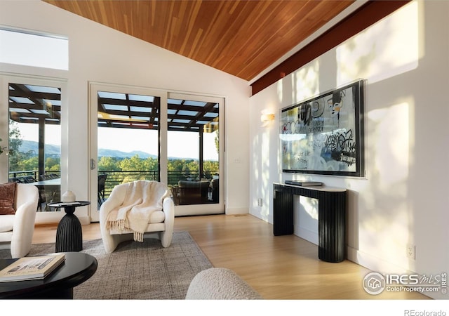 living room with wooden ceiling, a mountain view, plenty of natural light, and lofted ceiling