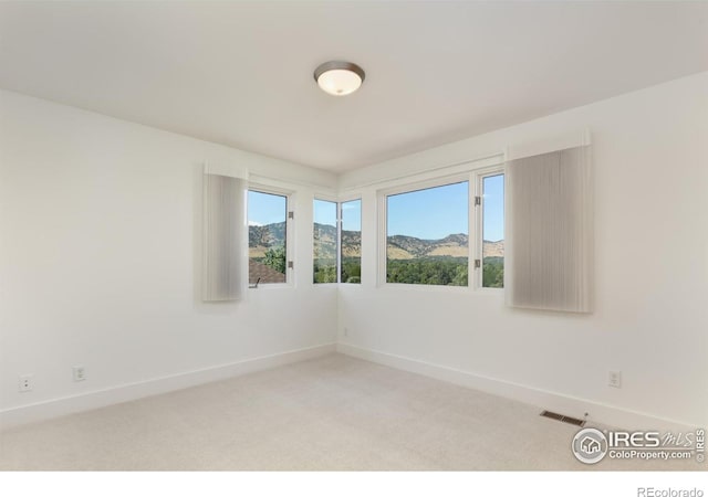 carpeted empty room featuring a mountain view