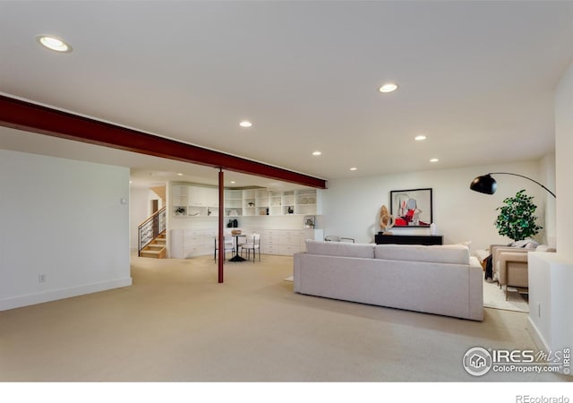 living room featuring beamed ceiling and light carpet