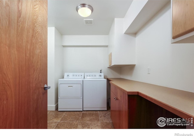 washroom featuring cabinets and washing machine and clothes dryer