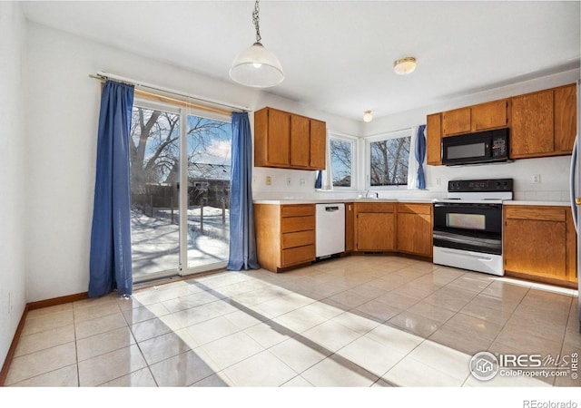 kitchen featuring dishwasher, light tile patterned floors, electric range, and decorative light fixtures