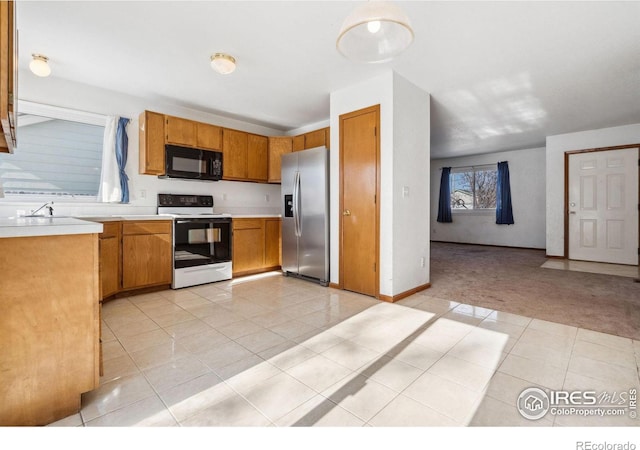 kitchen featuring electric stove, light colored carpet, stainless steel fridge, and sink