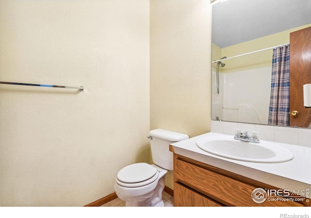 bathroom with a shower with curtain, vanity, tile patterned floors, and toilet