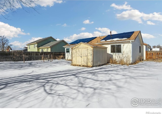 view of front of house with solar panels and a storage unit