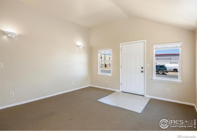 carpeted entrance foyer featuring lofted ceiling