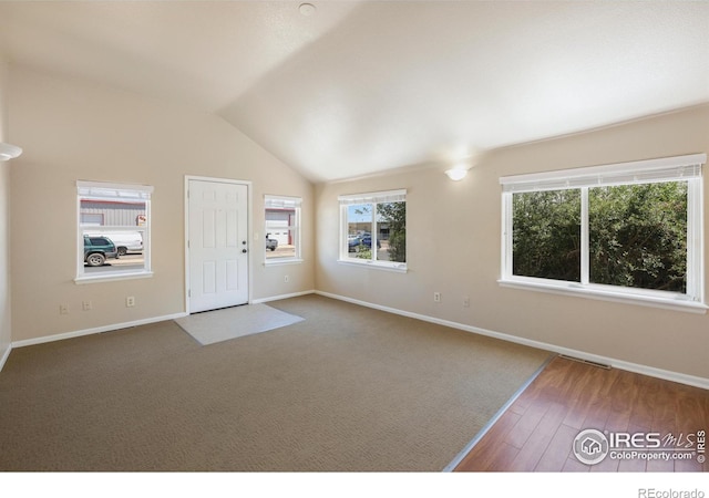 interior space with hardwood / wood-style flooring and vaulted ceiling