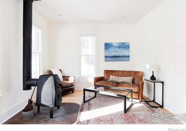 living room with light hardwood / wood-style floors and a wood stove