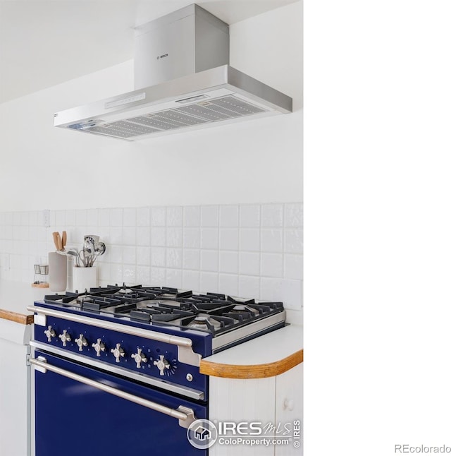 kitchen with stove, backsplash, and island exhaust hood