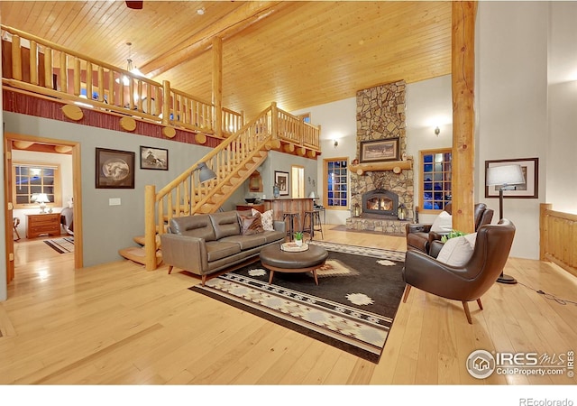 living room with high vaulted ceiling, a fireplace, hardwood / wood-style flooring, wood ceiling, and beam ceiling