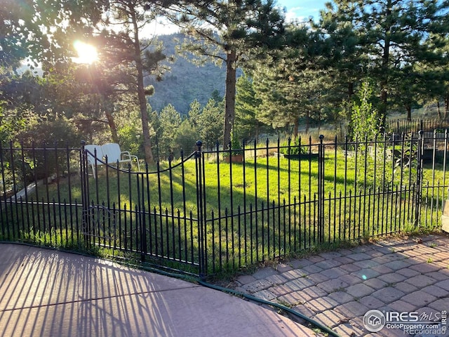 view of gate with a lawn