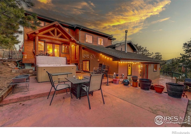 patio terrace at dusk with a hot tub