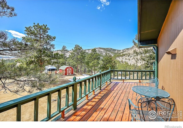 wooden terrace with a storage unit and a mountain view