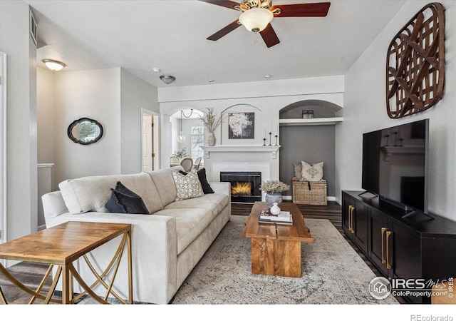 living room featuring ceiling fan, light hardwood / wood-style floors, and built in features