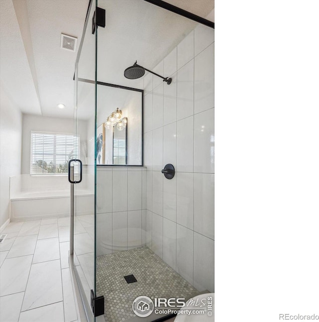 bathroom featuring shower with separate bathtub