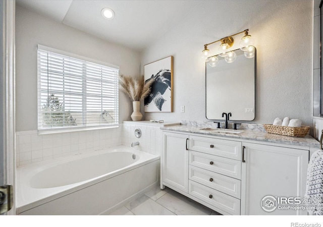 bathroom with vanity and a bath