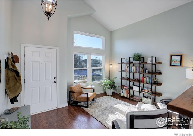 interior space with dark wood-type flooring, high vaulted ceiling, and a notable chandelier