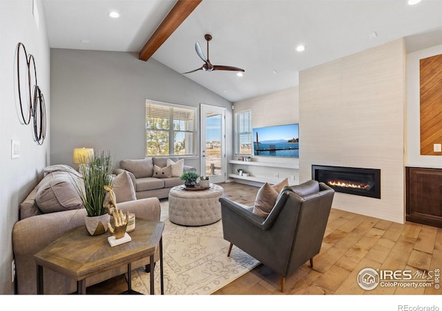 living room with a fireplace, light hardwood / wood-style flooring, vaulted ceiling with beams, and ceiling fan