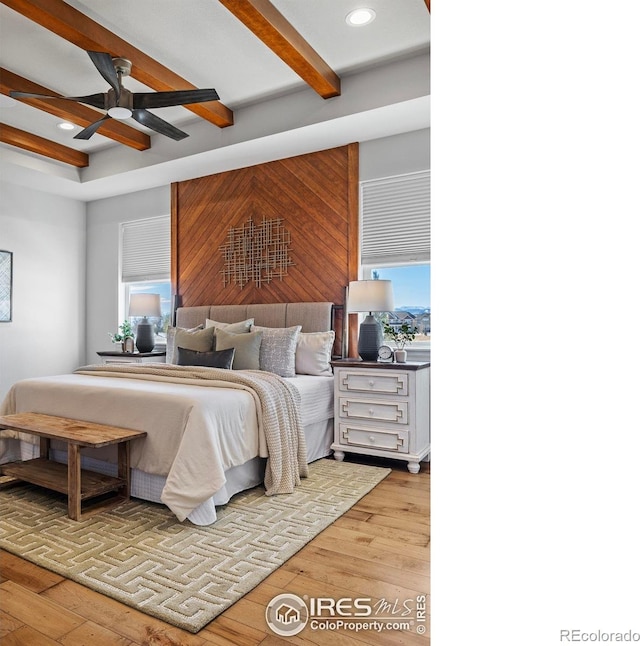 bedroom with light hardwood / wood-style floors and beamed ceiling