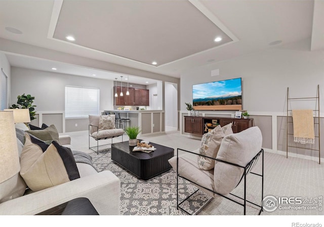 carpeted living room featuring a tray ceiling