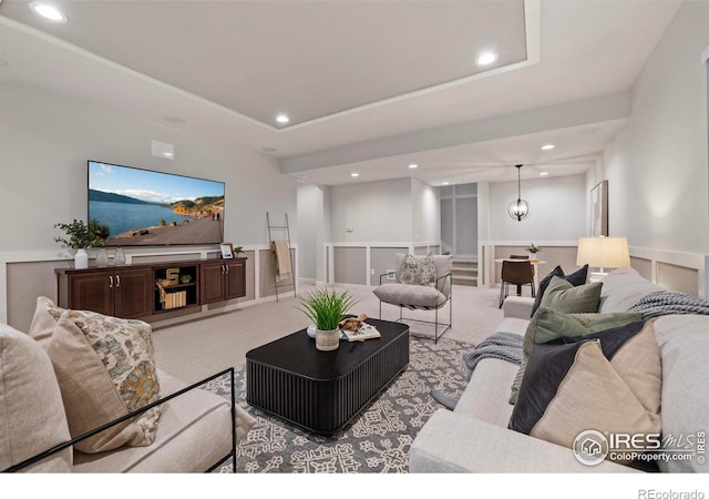 carpeted living room with a tray ceiling