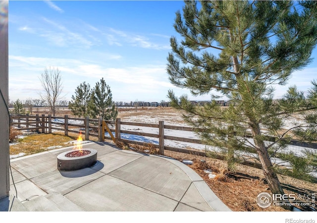 view of patio with a fire pit and a rural view