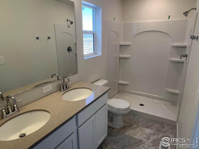 bathroom featuring a shower, vanity, and toilet