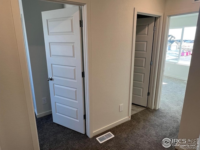 hallway with dark colored carpet