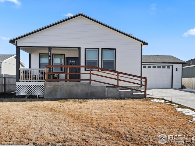 exterior space featuring driveway, covered porch, an attached garage, and a front lawn