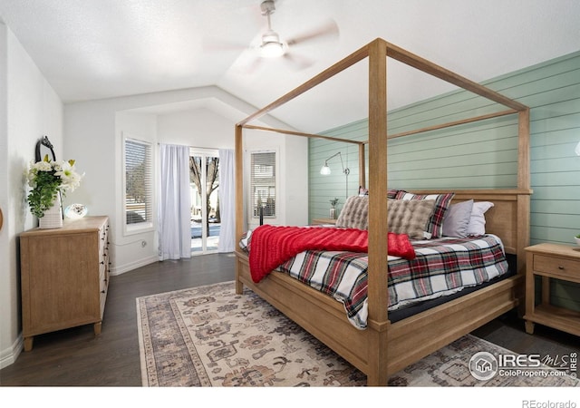 bedroom featuring ceiling fan, wooden walls, dark hardwood / wood-style flooring, and vaulted ceiling