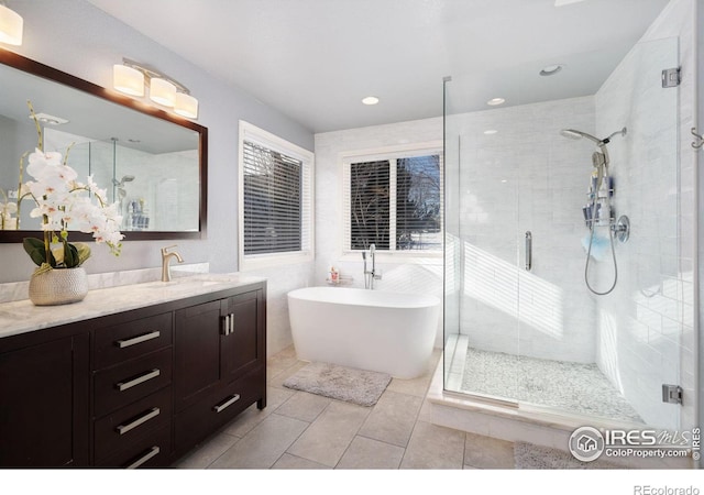 bathroom with tile patterned flooring, vanity, and separate shower and tub