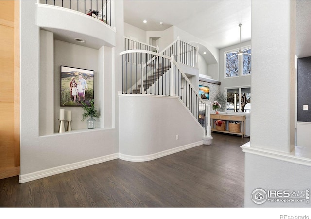 stairway with a towering ceiling and hardwood / wood-style floors