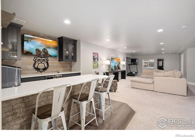 kitchen with tasteful backsplash, dark colored carpet, and a breakfast bar area