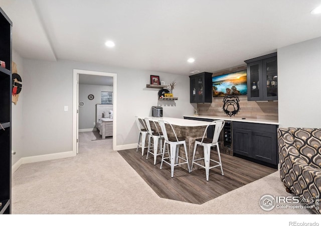 dining area with wine cooler, bar area, and dark hardwood / wood-style flooring