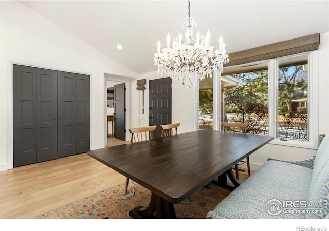 dining space featuring lofted ceiling, a chandelier, and light hardwood / wood-style flooring