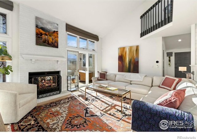 living room with a fireplace and high vaulted ceiling