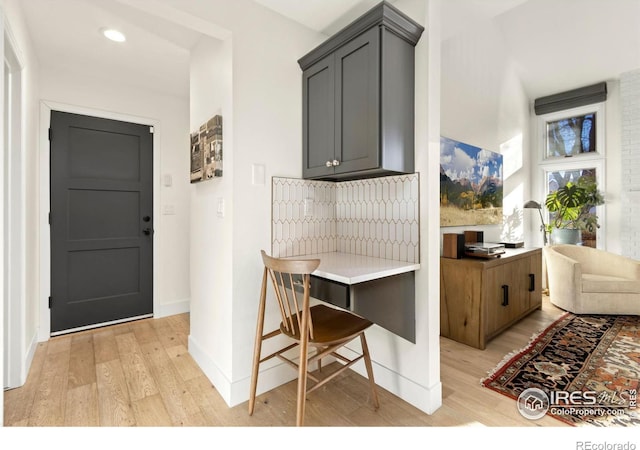 kitchen featuring a kitchen breakfast bar, gray cabinetry, and light wood-type flooring