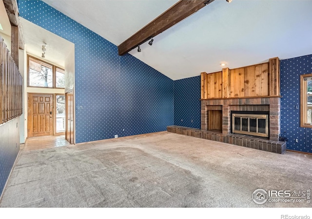 unfurnished living room with beamed ceiling, carpet flooring, high vaulted ceiling, and a brick fireplace