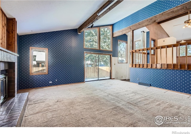 unfurnished living room featuring carpet, vaulted ceiling with beams, and ceiling fan