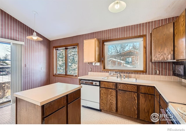 kitchen with vaulted ceiling, pendant lighting, dishwasher, sink, and electric stove