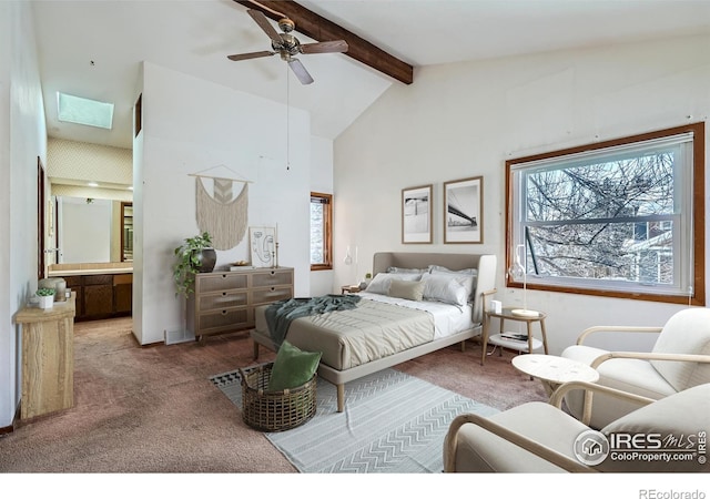 bedroom featuring connected bathroom, lofted ceiling with skylight, ceiling fan, and carpet flooring