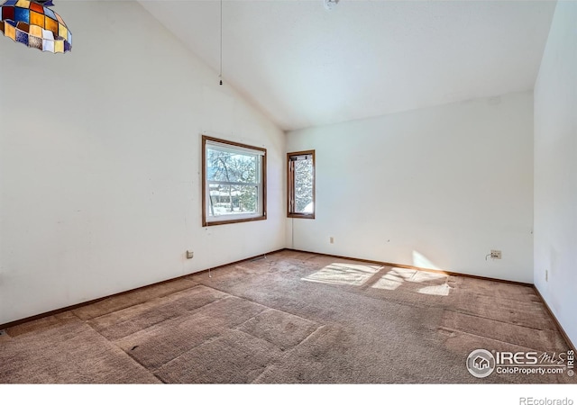 carpeted spare room featuring high vaulted ceiling