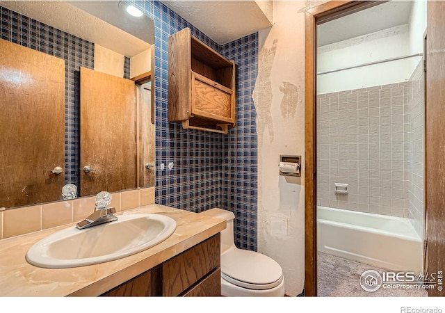 full bathroom featuring washtub / shower combination, vanity, and toilet