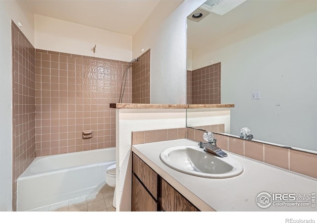 full bathroom featuring tiled shower / bath, tile patterned floors, toilet, and vanity